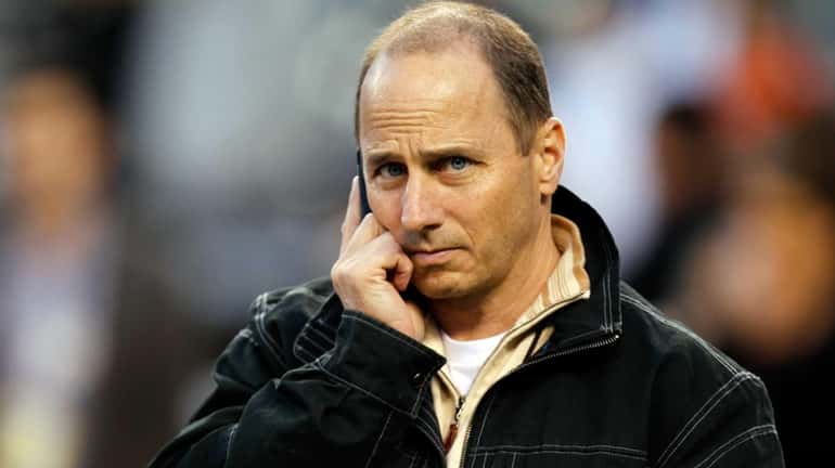 Yankees general manager Brian Cashman talks on the phone on...