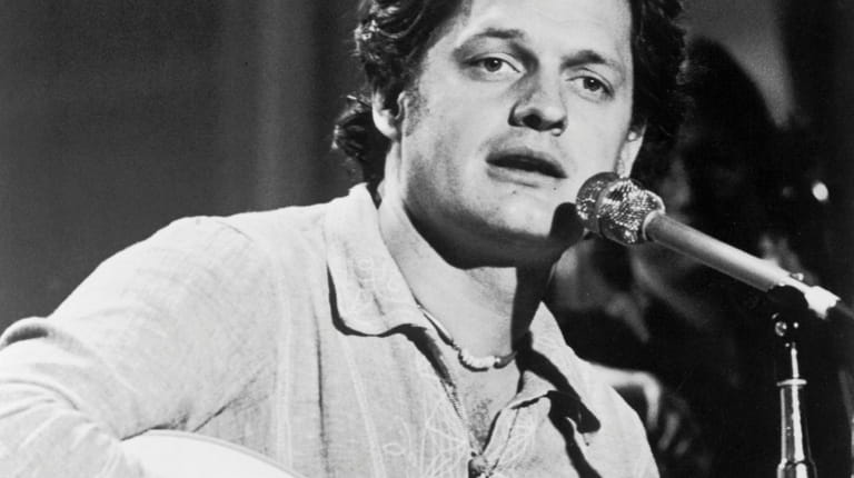  Harry Chapin plays the guitar and sings on stage during...