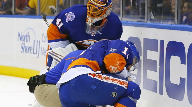 Lubomir Visnovsky of the New York Islanders is tended to...
