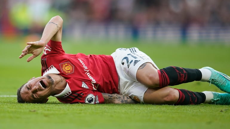 Manchester United's Antony lies on the pitch in pain during...