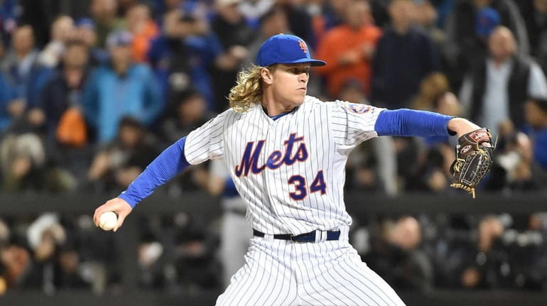 Mets starter Noah Syndergaard throws in the first inning of...
