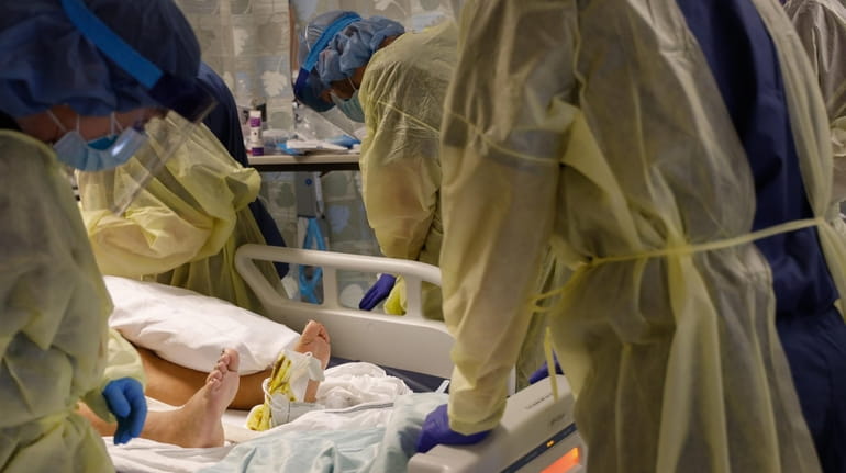 Medical staff tend to a patient in a medically induced coma.