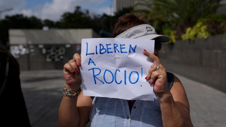 A protester holds a sign that reads in Spanish "Release...