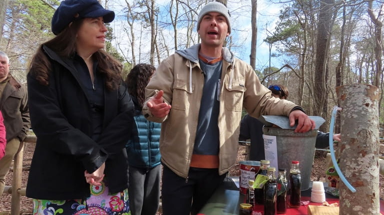 Judith Vogel, left, and Ryan Hegarty, right, discuss maple syrup...