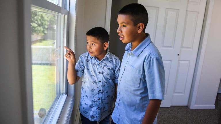 Bryan Castillo, 9, and his brother Luis, 11, inspect thir...