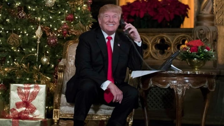 President Donald Trump speaks with children as they track Santa's...