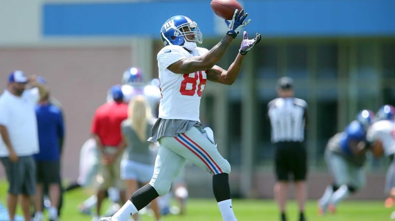 Giants wide receiver Mario Manningham makes a catch during training...