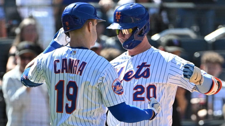 The Mets' Mark Canha greets Pete Alonso after Alonso's solo home...