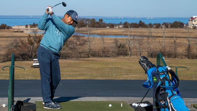 Ani Chakrabarti of Northport practices his swing at the driving...