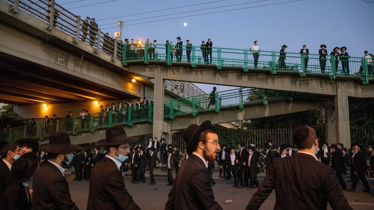 Ultra orthodox Jews dance as they block a highway during...