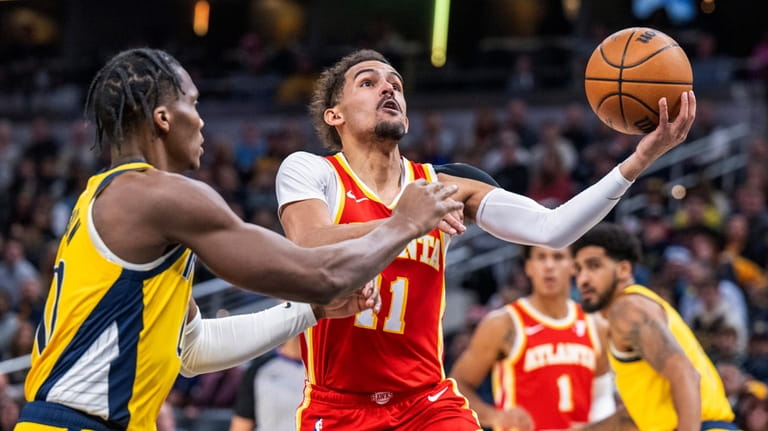 Atlanta Hawks guard Trae Young (11) shoots while defended by...