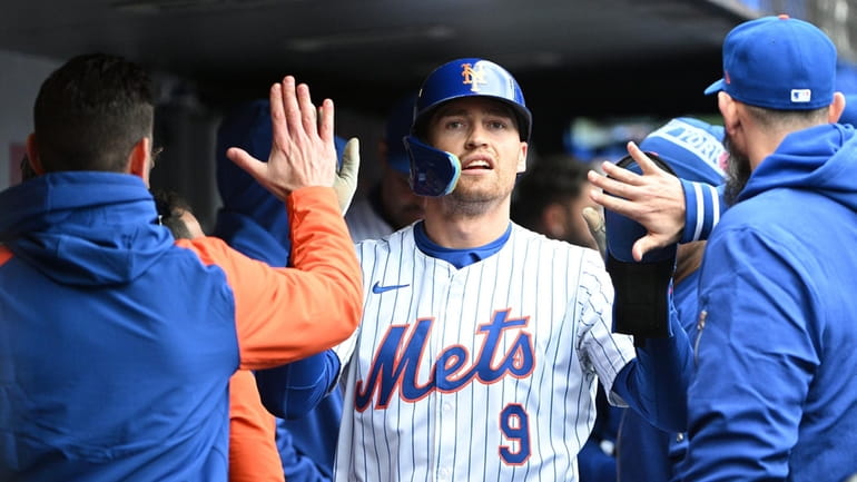 Mets centerfielder Brandon Nimmo is greeted in the dugout after...