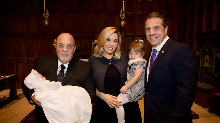 Billy Joel holding daughter Remy, his wife Alexis holding daughter...