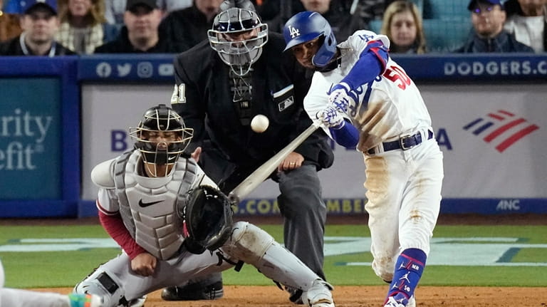 Los Angeles Dodgers' Mookie Betts, right, hits a solo home...