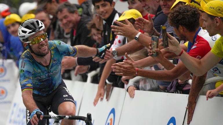 Britain's Mark Cavendish is cheered by fans as he completes...