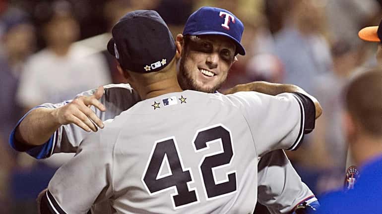 American League relief pitchers Mariano Rivera and Joe Nathan hug...