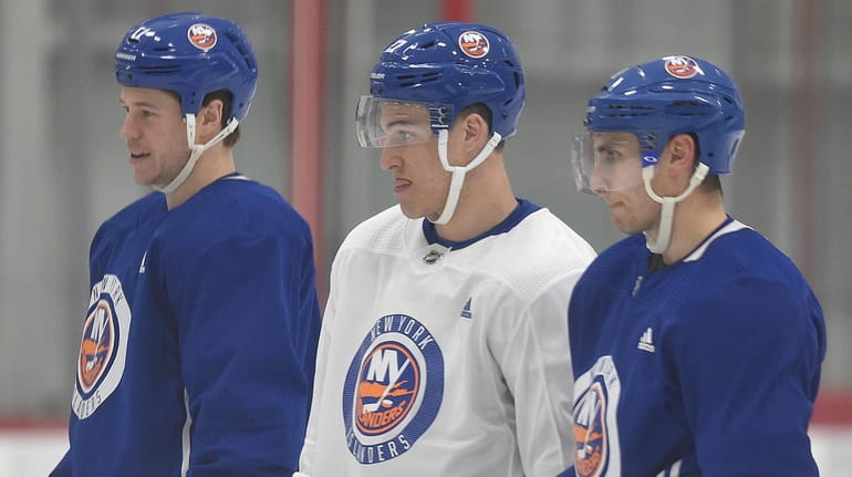 Islanders captain Anders Lee, center, stands alongside teammates Matt Martin, left,...
