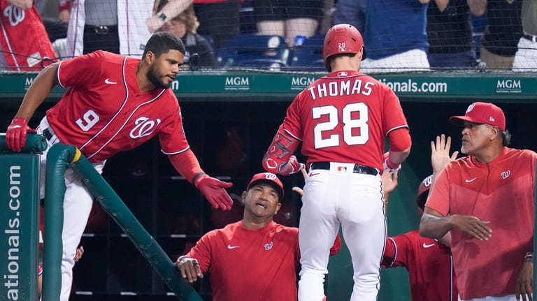 Washington Nationals' Lane Thomas returns to the dugout after his...