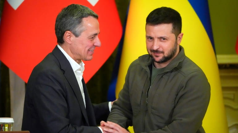 Ukrainian President Volodymyr Zelenskyy, right, shakes hands with Swiss President...