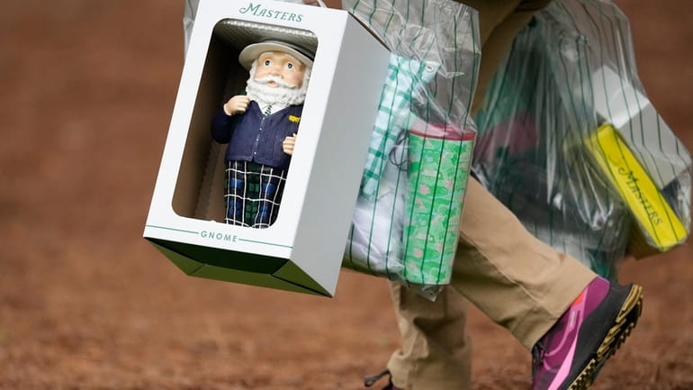 A patron carries a Masters gnome, a one-foot high ceramic...