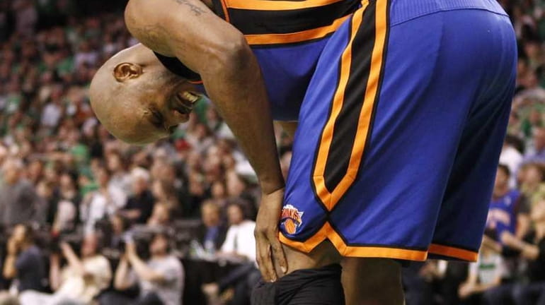 New York Knicks' Chauncey Billups grabs his knee after a...