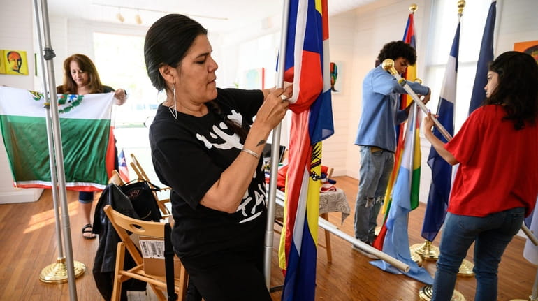Margarita Espada helps prepare Latin American flags that will be...
