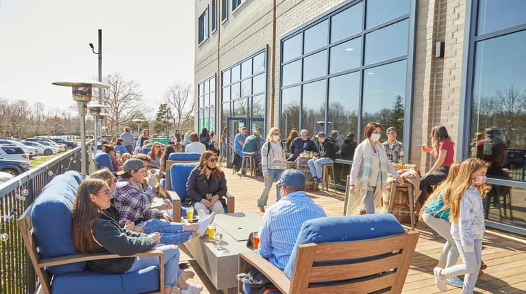 Patrons enjoy outdoor dining at Peconic County Brewing in Riverhead.