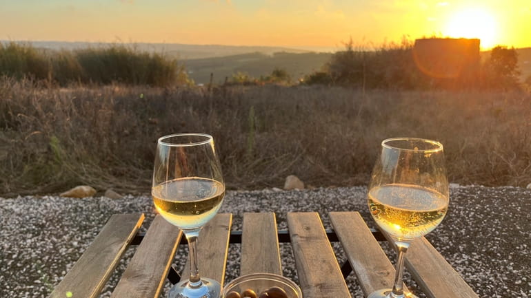 Glasses of Vinho Verde and local olives appear at sunset...