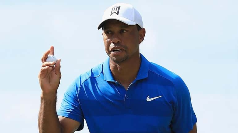 Tiger Woods acknowledges the crowd on the sixth green during the...