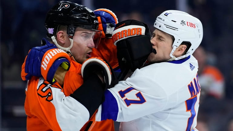 Philadelphia Flyers' Rasmus Ristolainen, left, wrestles with New York Islanders'...