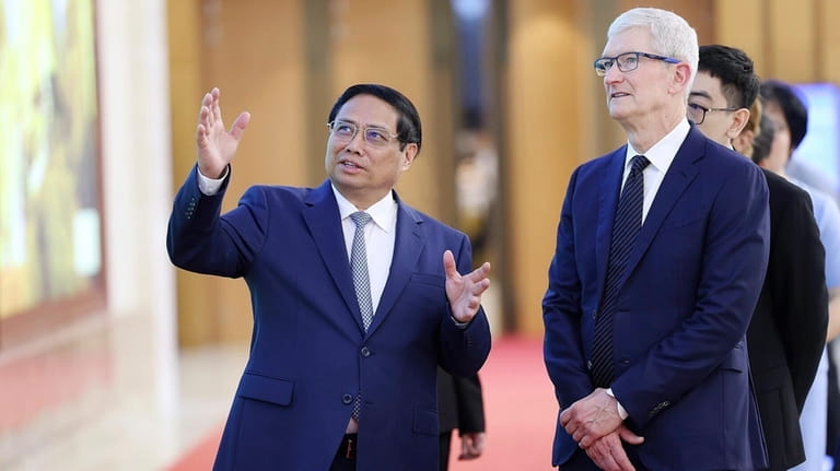 Vietnamese Prime Minister Pham Minh Chinh, left, speaks to Apple...