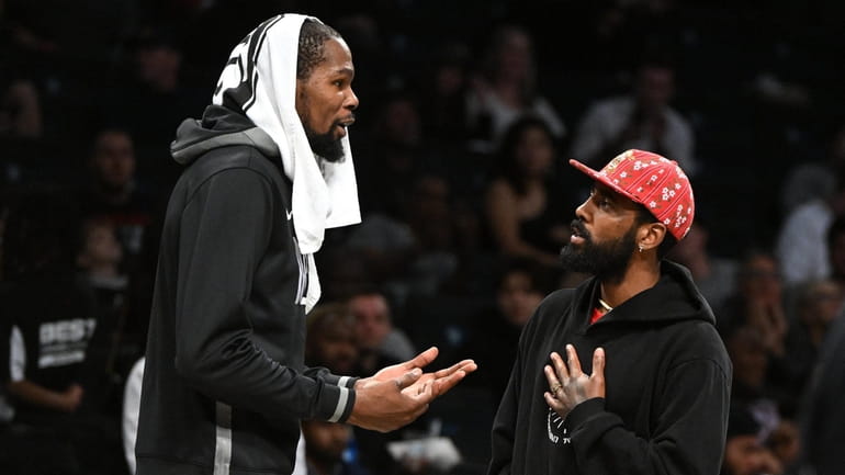 Nets' Kevin Durant and Kyrie Irving talk during a timeout...
