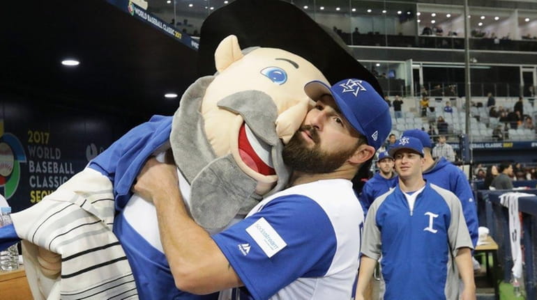 Infielder Cody Decker holds Israel's team mascot The Mensch after...