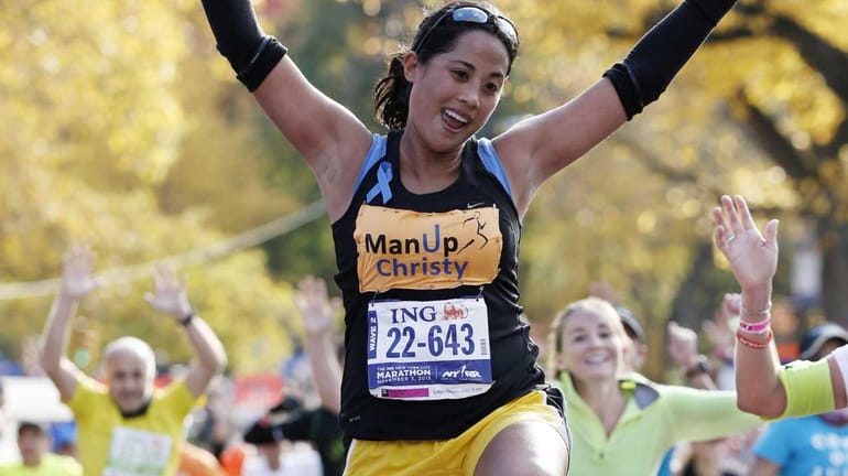 Christy Pasion of New York leaps across the finish line...
