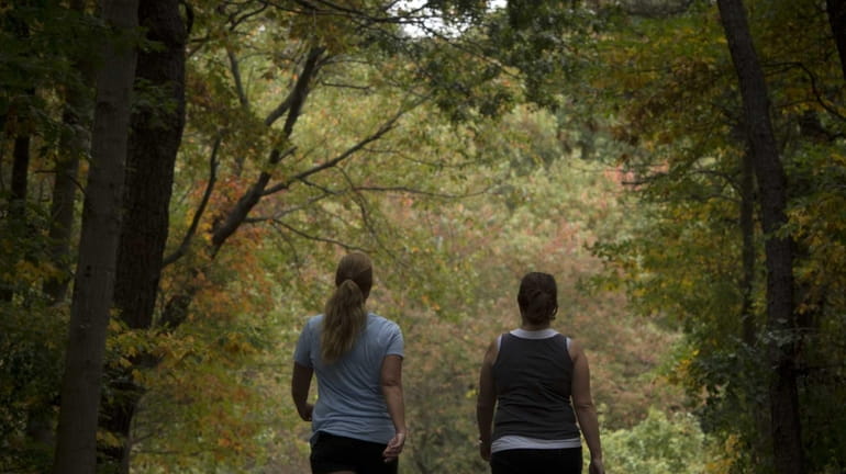 Two women walk around the 2-plus-mile exercise path at Harold...