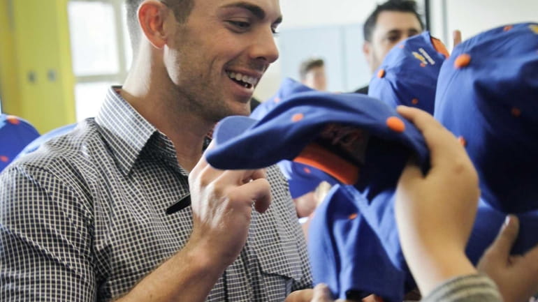 David Wright distributes caps and signs autographs for students at...