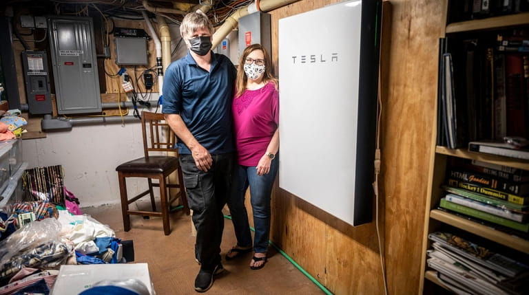 Erik Putz and his wife, Bonnie Burton, by the Tesla solar-powered backup...