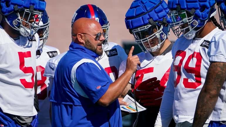 Giants head coach Brian Daboll, center, speaks with his first-string...
