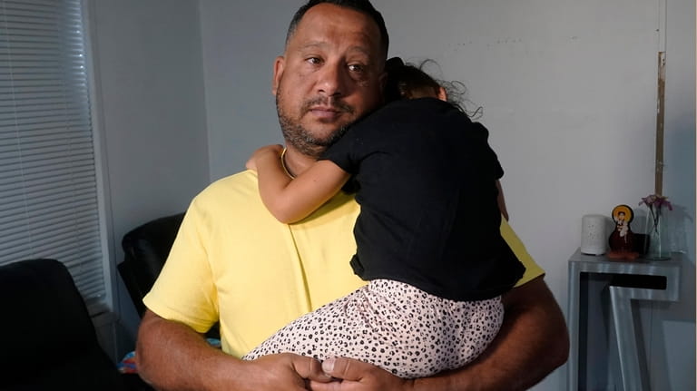 Victor Macedo holds his daughter Sonia at their home, Wednesday,...