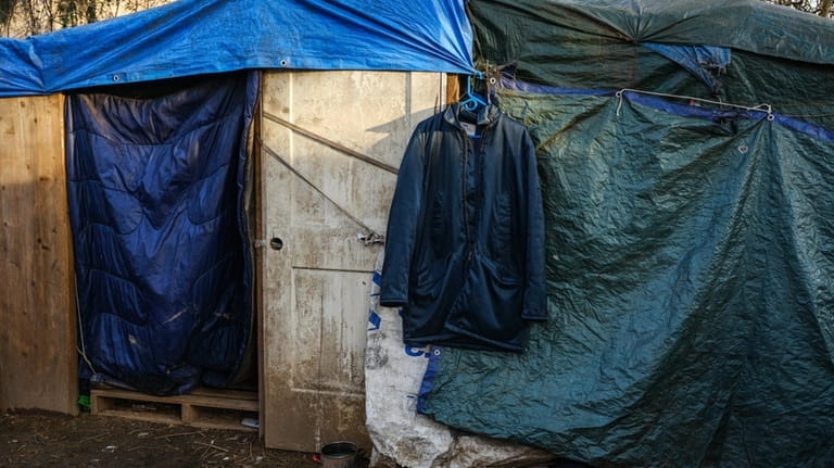 Living conditions include makeshift tents and housing at the migrant...