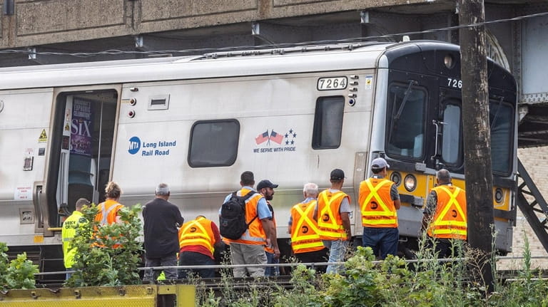 MTA officials and workers at the derailed Long Island Raid...