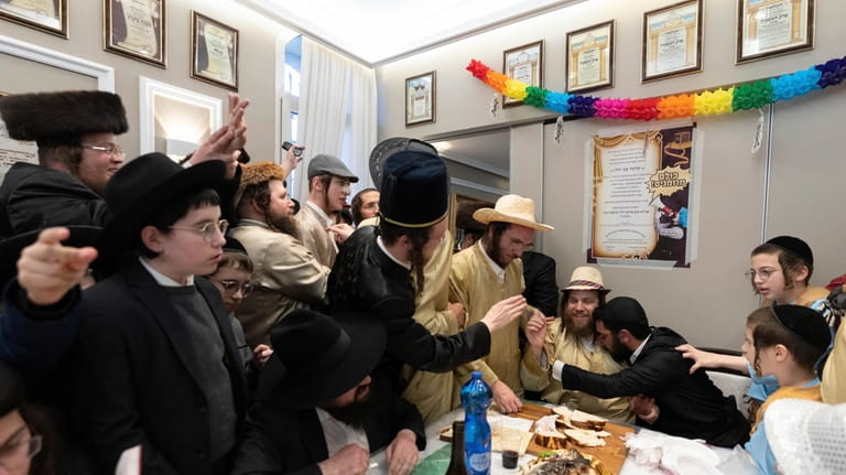 Ultra-Orthodox Jewish men and children, some in costumes, celebrate the...