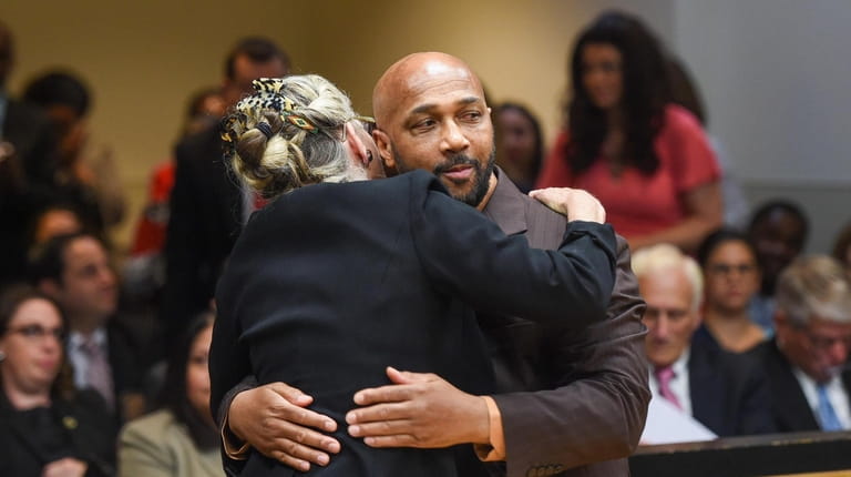 Keith Bush is embraced by his attorney, Adele Bernhard, inside...