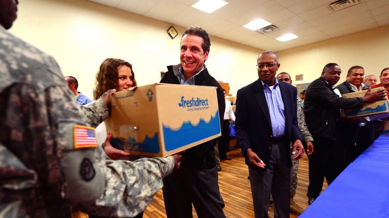 Governor Andrew Cuomo and his daughter, Cara, left, help deliver...