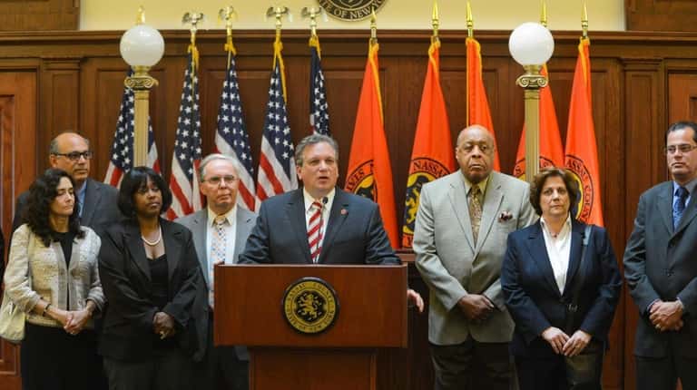 Nassau County Executive Edward P. Mangano, surrounded by members of...