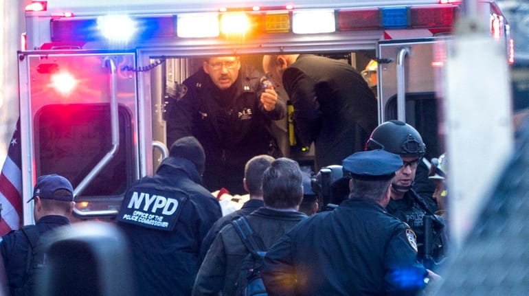 NYPD and FDNY officials place a person into an ambulance...