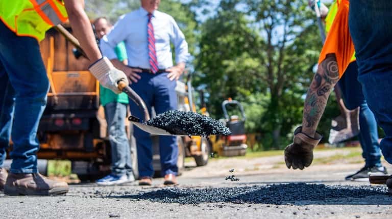 Crews fix a pothole in Commack as Suffolk County Executive...
