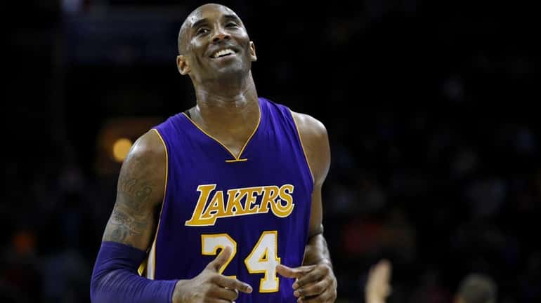 Los Angeles Lakers' Kobe Bryant smiles as he jogs to...