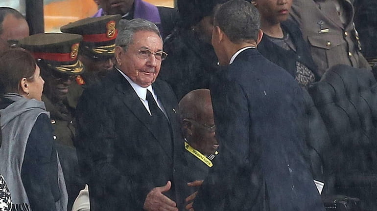 President Barack Obama shakes hands with Cuban President Raul Castro...