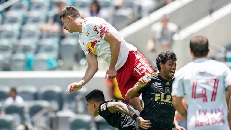 Red Bulls defender Sean Nealis jumps up to head the ball...